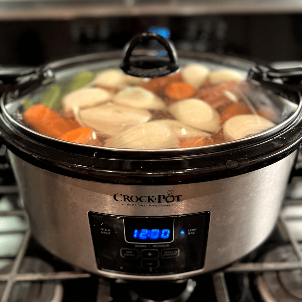 chicken bones, meat, carrots, celery, onions, dill, and sea salt in a crock pot to make chicken bone broth, an upgraded chicken broth with more nutrients
